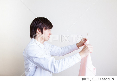 洗濯物を干す若い男性 21884419