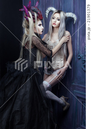 Two women with horns on their heads. 21901379