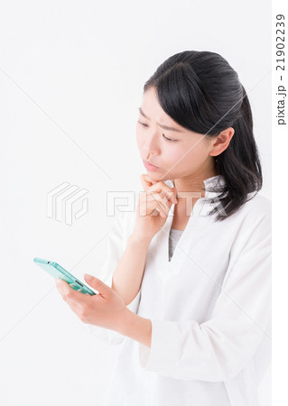 スマホの画面を見ながら考える女性 21902239