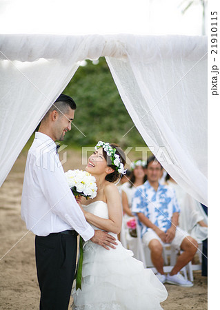 ビーチウェディングをする新郎新婦 ビーチウェディングをする新郎新婦 21910115