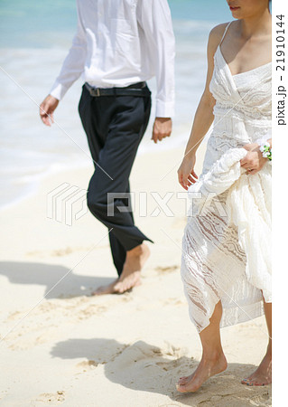ビーチウェディングをする新郎新婦 21910144