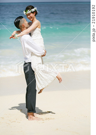 ビーチウェディングをする新郎新婦 21910192