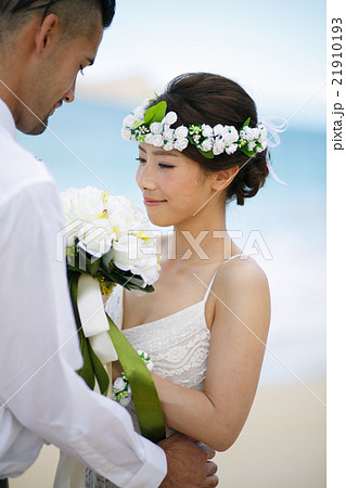 ビーチウェディングをする新郎新婦 21910193