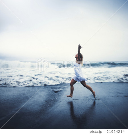 Young Woman with Arms Raised by the Beach Concept 21924214