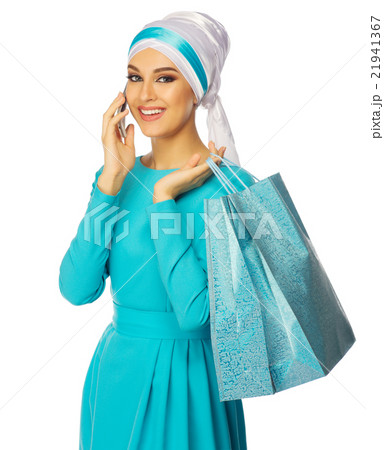 Muslim woman in blue dress with bags and phone Muslim woman in blue dress with bags and phone 21941367