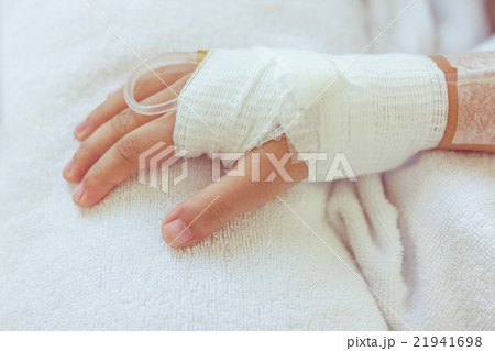 Saline intravenous drip in child's patient hand. 21941698