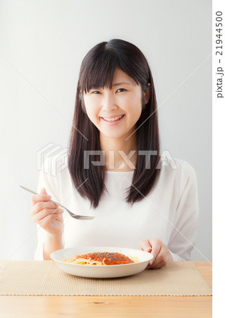 パスタを食べる女性 ミートソース サラダ トマト レタス ツナの写真素材