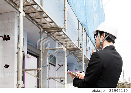 建物の確認をするヘルメット姿の男性 21945119