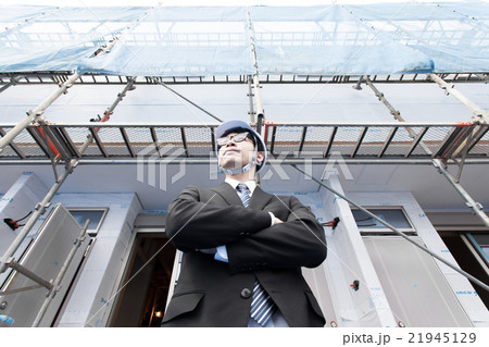 建物の確認をするヘルメット姿の男性 21945129