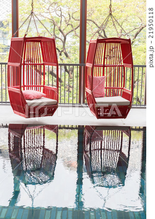 red wicker chair beside swimming pool red wicker chair beside swimming pool 21950118