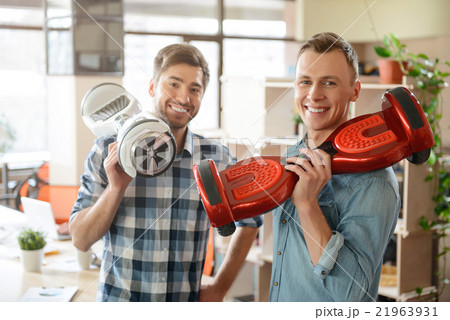 Positive smiling  men holding  gyro scooters  21963931