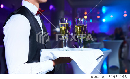 Waiter serving champagne on a tray Waiter serving champagne on a tray 21974148