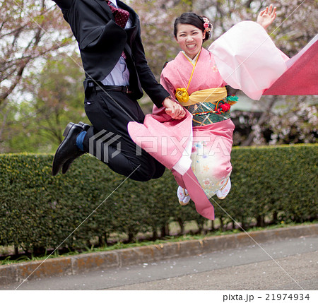 振袖姿の女性と男性のジャンプの写真素材