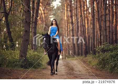 Beautiful woman riding horse in forest 21974976