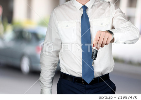 Young successful businessman offering a car key. Young successful businessman offering a car key. 21987470
