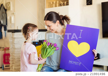 Mothers day, girl giving flowers and card to her Mothers day, girl giving flowers and card to her 21991496