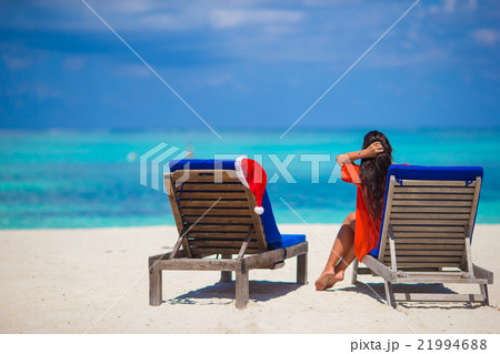 Red santa hat on chair longue at tropical white Red santa hat on chair longue at tropical white 21994688