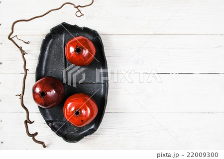 Many ceramic red pomegranates flat lay 22009300