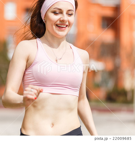 Young happy woman jogging in the street Young happy woman jogging in the street 22009685