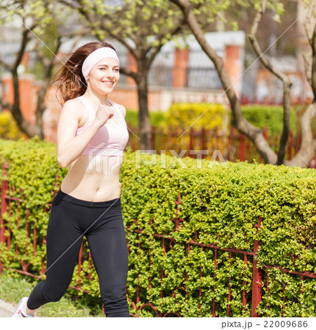 Young happy woman jogging in the street 22009686