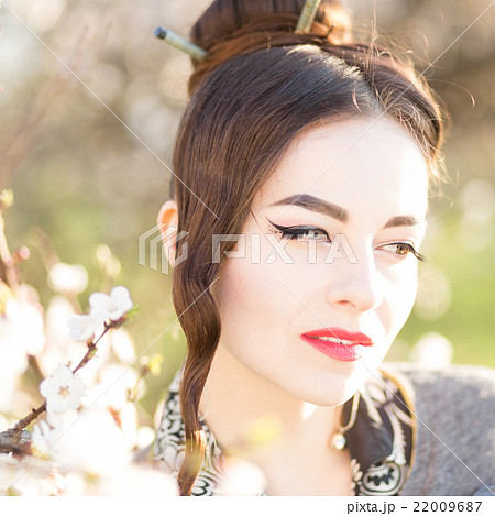 Beautiful young caucasian woman near blooming tree 22009687