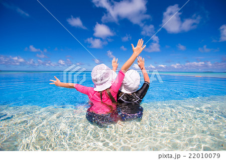 Adorable little girls playing in outdoor swimming 22010079