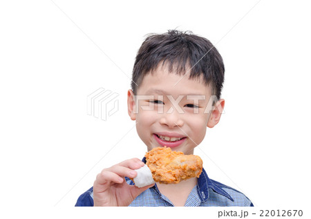 Young Asian boy eating fried chicken over white Young Asian boy eating fried chicken over white 22012670