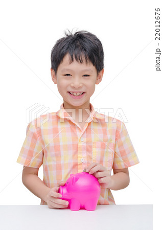 Happy Asian boy inserting coin into piggy bank Happy Asian boy inserting coin into piggy bank 22012676