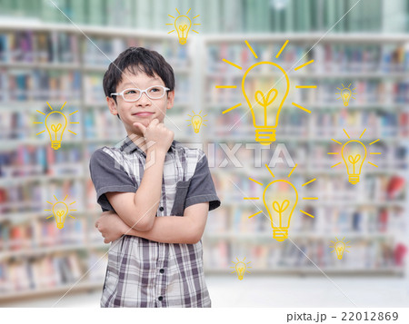 Young boy thinking with light bulbs in library 22012869