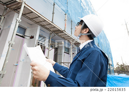 図面を持って建設現場を見る男性 22015635
