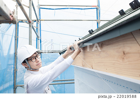 屋根の足場で作業する建築現場の作業員 屋根の足場で作業する建築現場の作業員 22019588