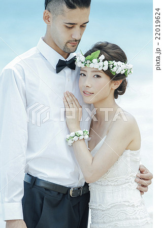ビーチウェディングをする新郎新婦 22019624