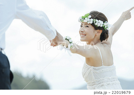 ビーチウェディングをする新郎新婦 22019679