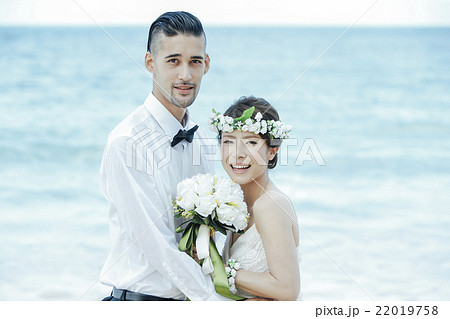 ビーチウェディングをする新郎新婦 22019758