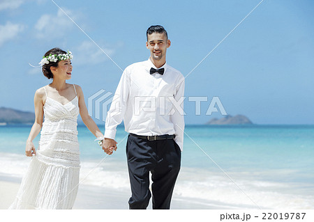 ビーチウェディングをする新郎新婦 22019787
