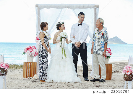 ビーチウェディングをする新郎新婦 22019794