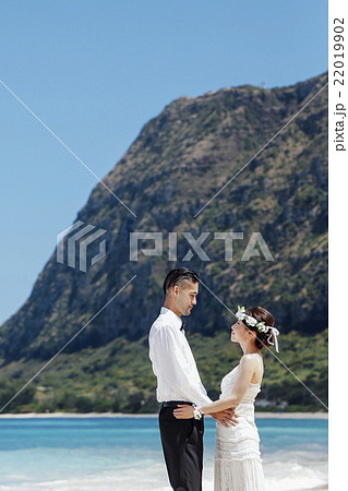 ビーチウェディングをする新郎新婦 22019902