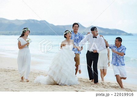ビーチウェディングをする新郎新婦 ビーチウェディングをする新郎新婦 22019916
