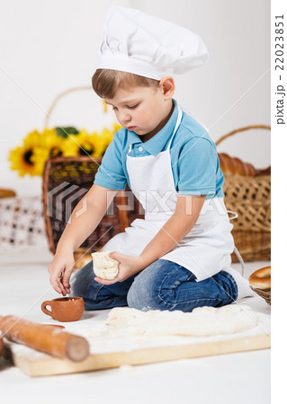 Little boy wearing chef hats baking a pie Little boy wearing chef hats baking a pie 22023851