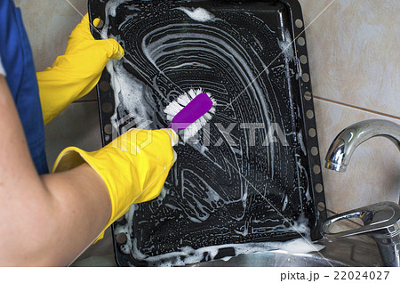 Woman cleaning pan with brush Woman cleaning pan with brush 22024027