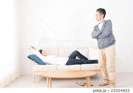ソファーで寝る妻をにらむ夫の写真素材 2242