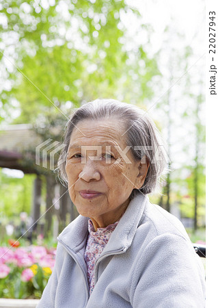 公園で寛ぐ微笑むカメラ目線のシニア女性 22027943