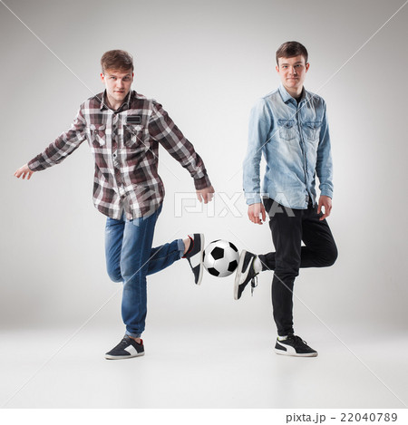 The two boys with balls on gray background 22040789