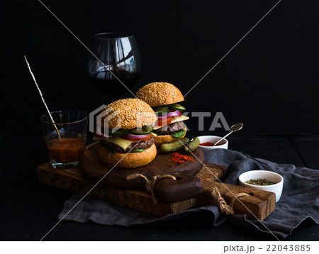 Fresh beef burgers on rustic wooden boards with 22043885