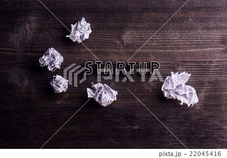 Desk with start up sign and crumpled paper balls 22045416
