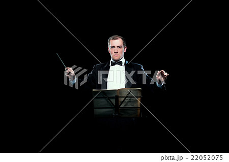 Studio photo of music conductor holding his baton Studio photo of music conductor holding his baton 22052075