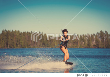 Young woman study riding wakeboarding on a lake Young woman study riding wakeboarding on a lake 22059555