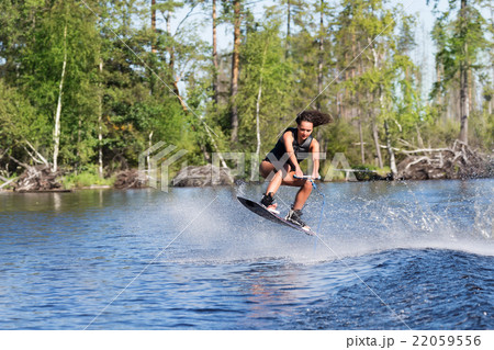 Woman study wakeboarding on a lake Woman study wakeboarding on a lake 22059556