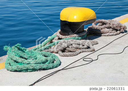 Yellow mooring bollard and nautical ropes 22061331