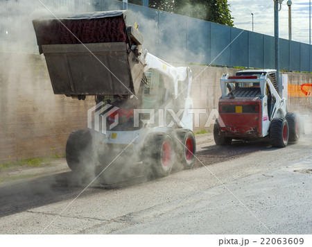 Two excavators perform milling of asphalt Two excavators perform milling of asphalt 22063609